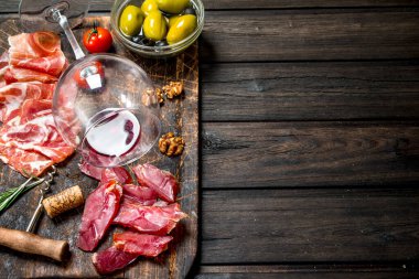 Meze arka plan. Kırmızı şarap ile farklı et aperatifler. Ahşap bir arka plan üzerinde.