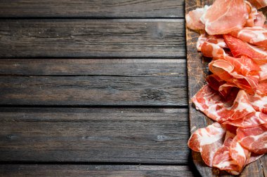 İspanyolca jambon kesme tahtası üzerinde. Ahşap bir arka plan üzerinde.