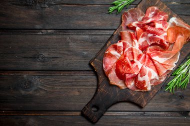 İspanyolca jambon kesme tahtası üzerinde. Ahşap bir arka plan üzerinde.