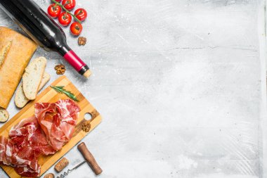 Geleneksel İspanyolca jambon ciabatta ve kırmızı şarap ile. Rustik bir arka plan üzerinde.