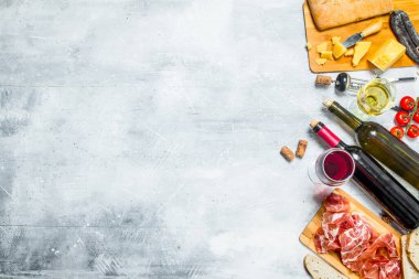 Meze arka plan. Kırmızı ve beyaz et ve peynir meze ile şarap. Rustik bir arka plan üzerinde.