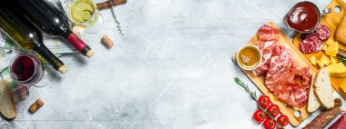 Meze arka plan. Kırmızı ve beyaz et ve peynir meze ile şarap. Rustik bir arka plan üzerinde.