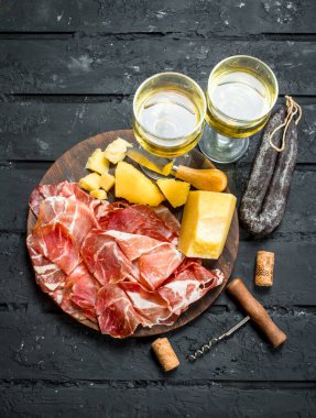 Meze arka plan. İtalyan meze beyaz şarap ile. Rustik siyah arka plan üzerine.