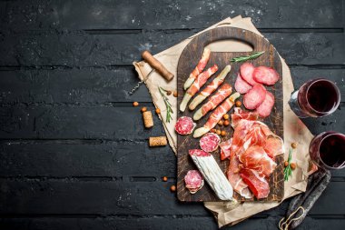 Meze arka plan. Kırmızı şarap ile geleneksel İtalyan meze. Rustik siyah arka plan üzerine.