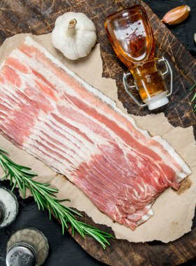 Ham pastırma biberiye ve baharatlar ile. Rustik siyah arka plan üzerine.