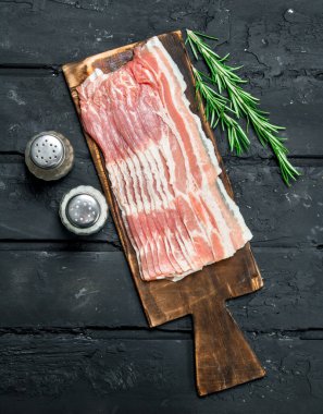 Biberiye dalları ile ham pastırma. Rustik siyah arka plan üzerine.