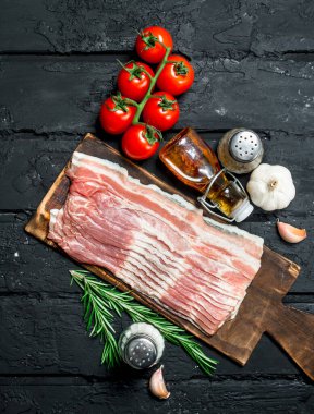 Domates ve baharat ile ham pastırma. Rustik siyah arka plan üzerine.