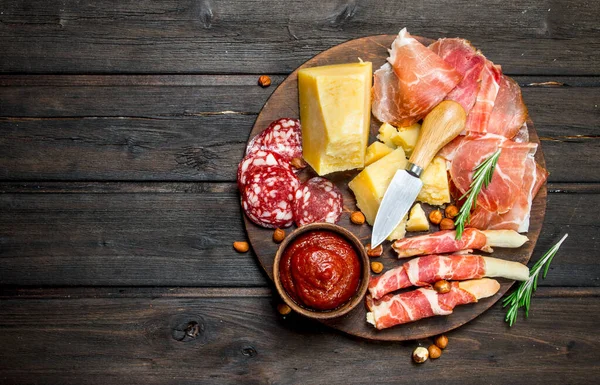 stock image Antipasto background.Board with traditional Italian snacks. On a wooden background.