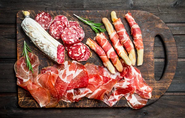 stock image Antipasto background. Assortment of meat snacks on the Board . On a wooden background.