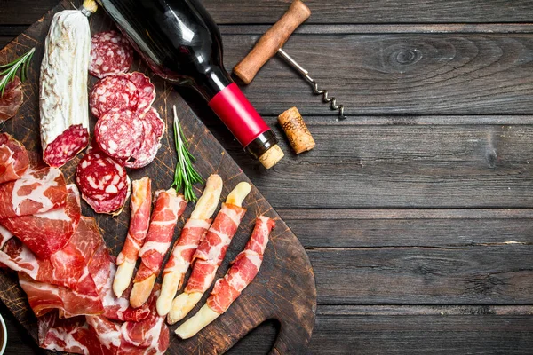 stock image Antipasto background.Italian meat appetizers with red wine. On a wooden background.