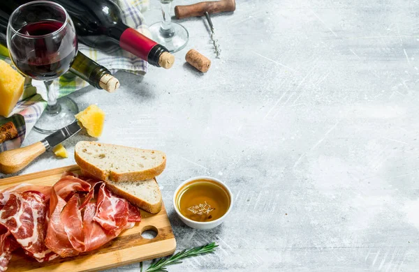 stock image Antipasto background. Red and white wine with meat and cheese appetizers. On a rustic background.