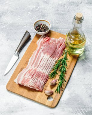 Ham pastırma biberiye ve baharatlar ile. Rustik bir arka plan üzerinde.