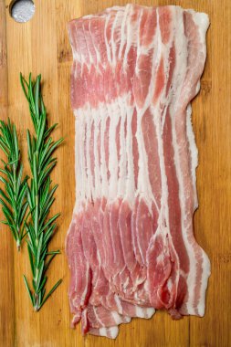 Biberiye dalları ile ham pastırma. Rustik bir arka plan üzerinde.