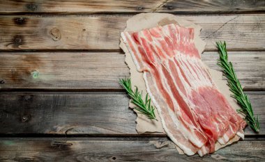 Kağıt üzerinde ham pastırma. Ahşap bir arka plan üzerinde.