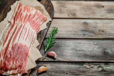 Kağıt üzerinde ham pastırma. Ahşap bir arka plan üzerinde.