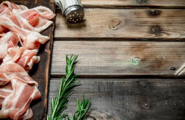 Baharat ve biberiye ile ham pastırma. Ahşap bir arka plan üzerinde.