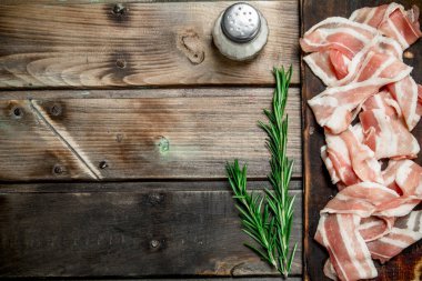 Baharat ve biberiye ile ham pastırma. Ahşap bir arka plan üzerinde.