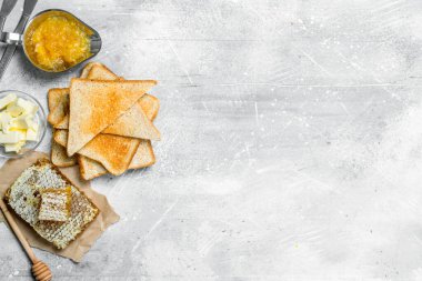 Kahvaltı. Kızarmış ekmek, bal portakal reçeli ve tereyağı ile. Rustik bir arka plan üzerinde.