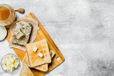 Kahvaltı. Tereyağı ve ballı ekmek. Rustik bir arka plan üzerinde.