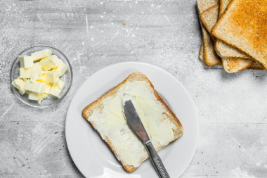 Kahvaltı. Kızarmış ekmek ve tereyağı. Rustik bir arka plan üzerinde.