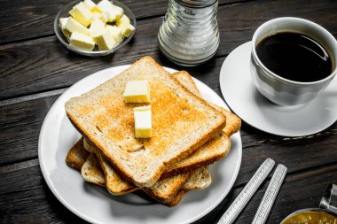 Kahvaltı. Tost ekmeği tereyağı ve aromatik kahve ile. Ahşap bir arka plan üzerinde.