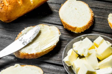 Taze ekmek ve tereyağı. Ahşap bir arka plan üzerinde.