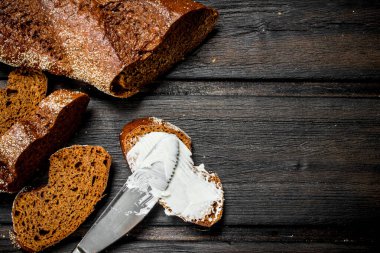 Taze çavdar ekmek ve tereyağı. Ahşap bir arka plan üzerinde.