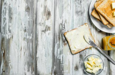 Kahvaltı. Tost ekmeği tereyağı ve portakal reçeli ile. Ahşap rustik arka plan üzerinde.