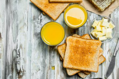Kahvaltı. Tost ekmeği tereyağı, bal ve portakal suyu ile. Ahşap rustik arka plan üzerinde.