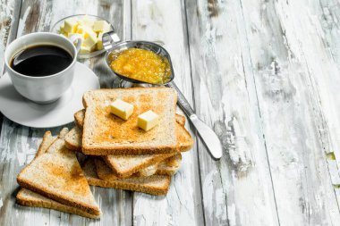 Kahvaltı. Tost ekmeği tereyağı ve sıcak kahve ile. Ahşap rustik arka plan üzerinde.