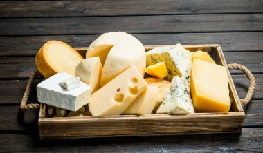 Üzüm ile ahşap bir tepsi içinde peynir farklı türleri. Ahşap bir arka plan üzerinde.