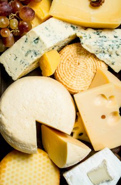 Peynir tepsiye farklı türde ürün yelpazesine. Ahşap bir arka plan üzerinde.