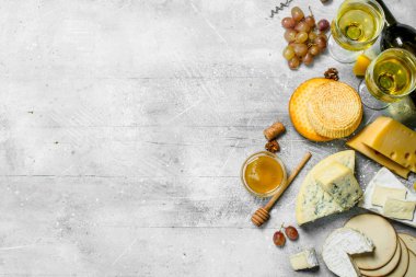 Beyaz şarap ve bal ile peynir türü ürün yelpazesine. Rustik bir arka plan üzerinde.