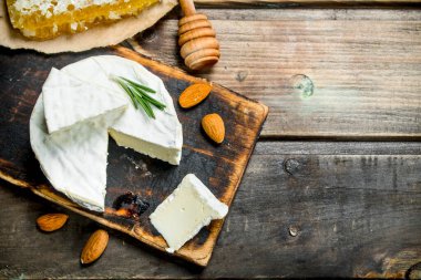 Brie peyniri bal ve fındık ile. Ahşap bir arka plan üzerinde.