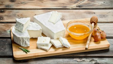 Brie peyniri ile fındık ve bal gemide. Ahşap bir arka plan üzerinde.