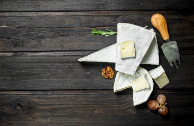 Brie peyniri ile fındık ve üzüm. Ahşap bir arka plan üzerinde.