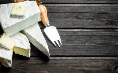 Brie peyniri bıçakla. Ahşap bir arka plan üzerinde.