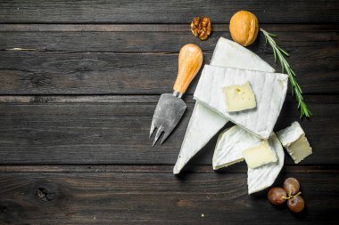 Brie peyniri bıçakla. Ahşap bir arka plan üzerinde.