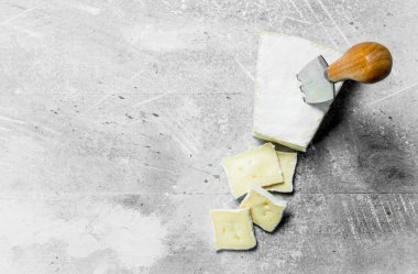 Brie peyniri bıçakla. Rustik bir arka plan üzerinde.