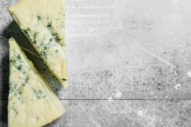 Mavi peynir parçalarını. Rustik bir arka plan üzerinde.