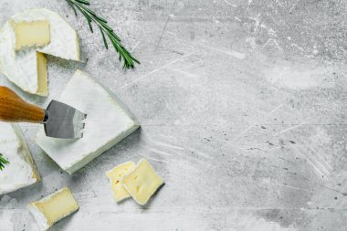 Brie peyniri bıçakla. Rustik bir arka plan üzerinde.