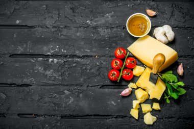 Parmesan peyniri domates, sarımsak ve zeytinyağı ile. Rustik siyah arka plan üzerine.