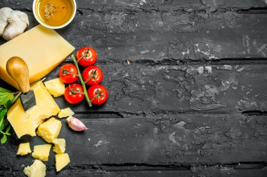 Parmesan peyniri domates, sarımsak ve zeytinyağı ile. Rustik siyah arka plan üzerine.