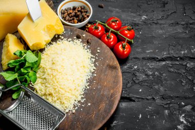 Çam fıstığı, domates ve otlar ile rendelenmiş Parmesan peyniri. Rustik siyah arka plan üzerine.