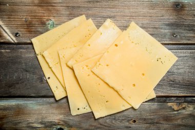 İnce dilim peynir. Ahşap bir arka plan üzerinde.