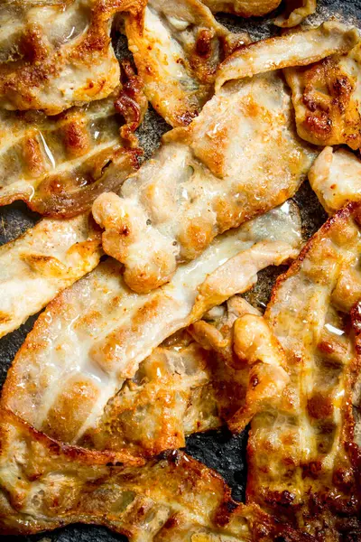 stock image Fried bacon in a frying pan. Top view