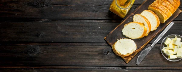 stock image Fresh bread and butter. On a Wooden background.