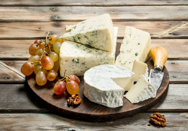 Blauw Brie Kaas Met Druiven Het Bord Een Houten Achtergrond — Stockfoto
