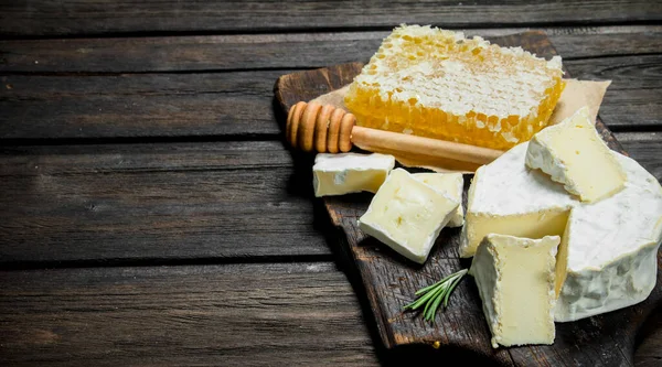 stock image Brie cheese with honey comb. On a wooden background.