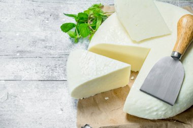 Yumuşak peynir bir dal nane ile. Rustik bir arka plan üzerinde.